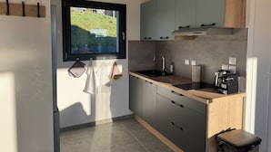 Una cocina moderna con ventana, armarios de madera, un lavamanos y una encimera.