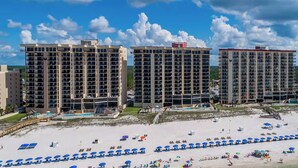 Un hotel sulla spiaggia con diversi edifici a grattacielo, una spiaggia sabbiosa e innumerevoli ombrelloni.
