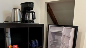 Ein kleiner Küchenbereich mit Kaffeemaschine, Wasserkocher und Aufbewahrungskörben.