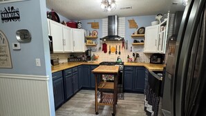 Una cocina con armarios de madera, una isla central y un refrigerador.