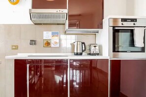 Uma cozinha equipada com micro-ondas, chaleira e forno.