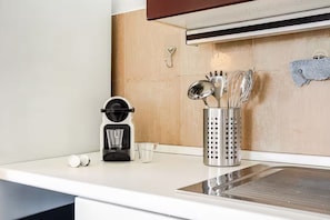 A kitchen counter with a coffee maker, a glass, and a utensil holder. - | Penthouse 186 | 3 Bedrooms and Private Terrace - 190SQM (Torino)