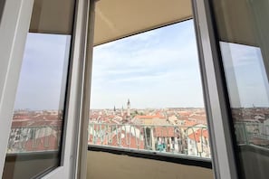 A window with a view of a cityscape, including buildings and a tower. - | Penthouse 186 | 3 Bedrooms and Private Terrace - 190SQM (Torino)
