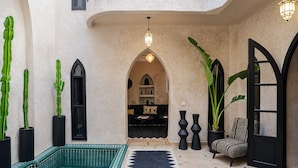 A courtyard with a pool, potted plants, a sofa, and a patterned rug. - Riad 1810 - Private Luxury Riad • Pool • Rooftop Views (Marrakesh)