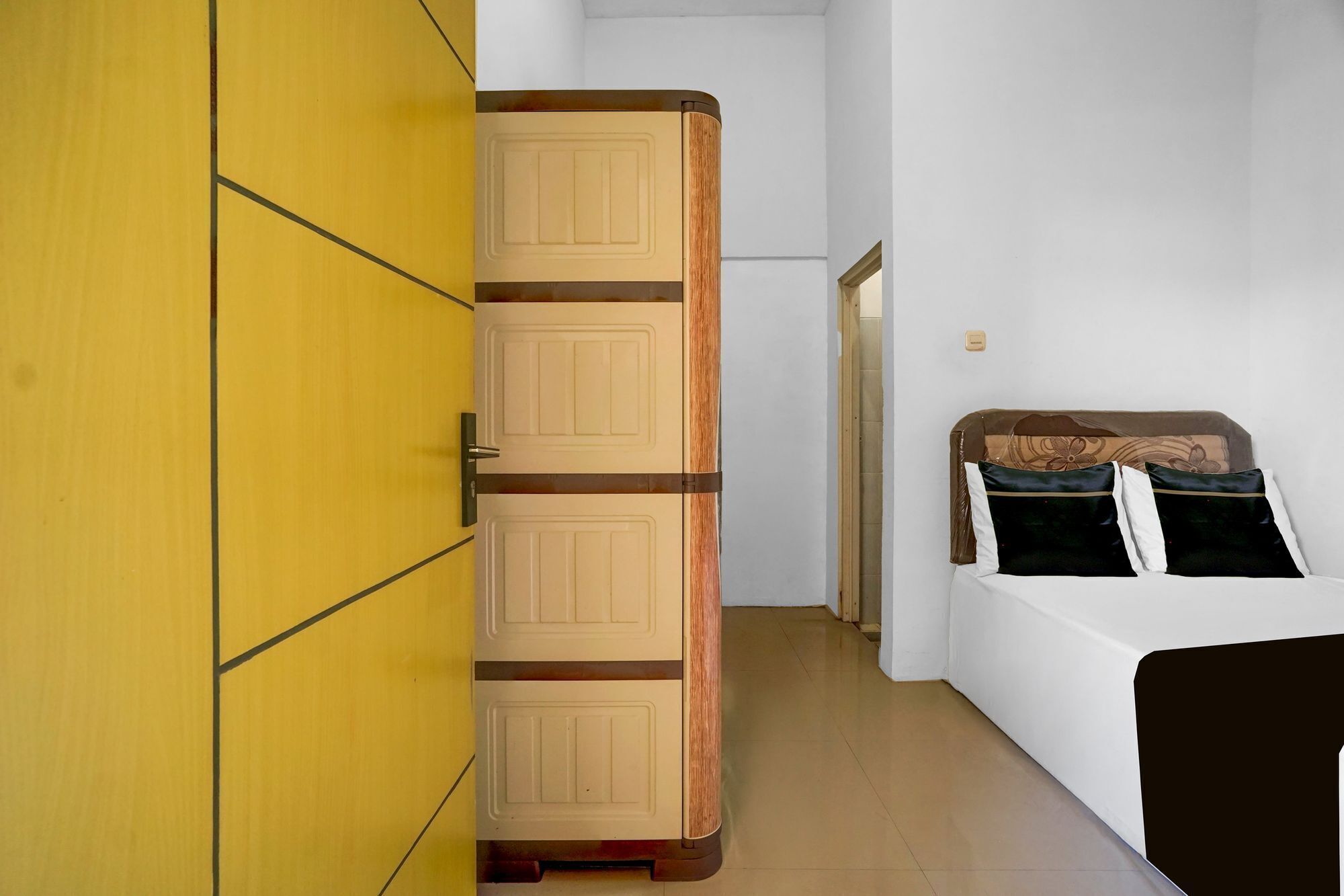 A bedroom with a bed, a wardrobe, and a door.