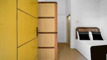 A bedroom with a bed, a wardrobe, and a door.