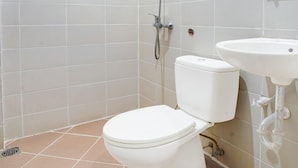 A bathroom with a toilet, a shower, and a sink.