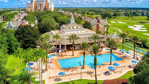 Un resort con piscina, sillas de descanso y palmeras.