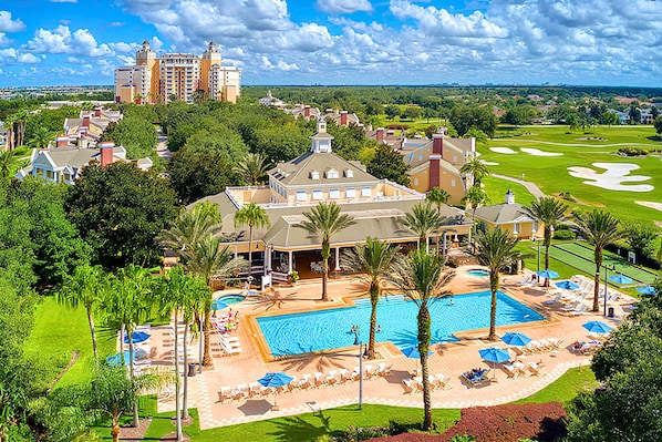 A resort with a swimming pool, lounge chairs, and palm trees. - Stylish Home with Pool Hot Tub and Parking (Kissimmee)