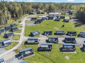 A modern residential complex with multiple two-story buildings, a central road, and surrounding greenery. - Villa orion 57 by Interhome (Kemiönsaari)