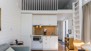 A compact kitchen with white cabinetry, a wooden countertop, and a built-in oven. - Villa orion 57 by Interhome (Kemiönsaari)