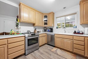 Una cocina con armarios de madera, electrodomésticos de acero inoxidable y un ventanal con vistas.