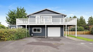 A two-story house with a balcony, garage, and a driveway. - Beautiful 4-bedroom house in enchanting Long Beach perfect for families (Long Beach)