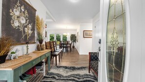 A dining area with a wooden table, chairs, and a patterned rug. - Beautiful 4-bedroom house in enchanting Long Beach perfect for families (Long Beach)