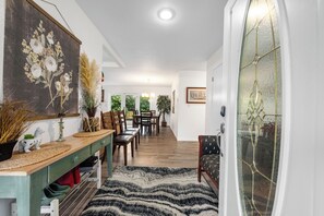 Un coin repas avec une table en bois, des chaises et un tapis à motifs.