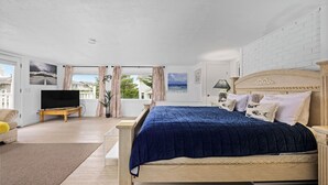 A bedroom with a bed, a TV, a window with curtains, and a view of the outdoors. - Beautiful 4-bedroom house in enchanting Long Beach perfect for families (Long Beach)