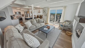 Un vaste espace de vie comprenant un ensemble de canapés, une table basse et une cheminée.