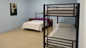 Un dormitorio con literas, un escritorio pequeño y una silla.