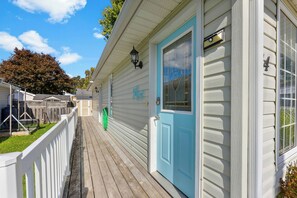 A house with a blue door, a white fence, and a small porch. - Lincoln Landing- Steps to the beach (Fort Erie)
