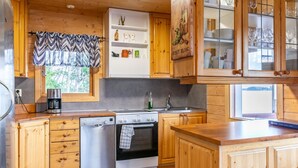 A kitchen with wooden cabinets, a dishwasher, a stove, and a coffee maker.