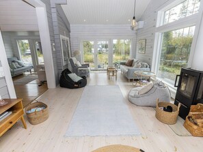 A spacious living room with a fireplace, seating area, and large windows.