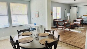 A dining area with a round table, four chairs, and woven placemats.