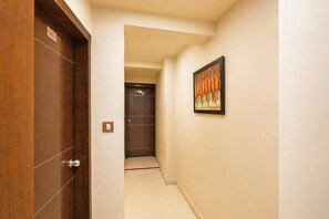 A hallway with a wooden door labeled '303' and a framed picture on the wall.