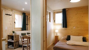 Um interior de madeira com uma cama, uma mesa e uma cadeira.