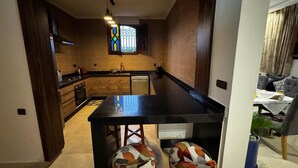 Une cuisine moderne avec un îlot central, des armoires en bois et un vitrail.