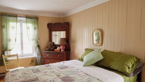 A bedroom with a bed, a dresser, a mirror, and a window with curtains. - Comforter and garden #281772 Au rythme d'avant... (Berthier-sur-Mer)