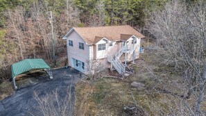 A two-story house with a covered porch and a staircase leading to a second level. - Cozy 1-bedroom basement apt with AC in brilliant Sevierville (Sevierville)