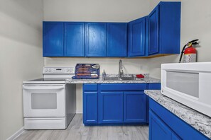 A kitchen with blue cabinets, a white stove, and a microwave. - Cozy 1-bedroom basement apt with AC in brilliant Sevierville (Sevierville)