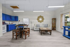 A modern kitchen with blue cabinets, a dining table with chairs, a white refrigerator, and a decorative wall piece. - Cozy 1-bedroom basement apt with AC in brilliant Sevierville (Sevierville)