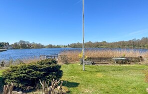 A lakeside view with a dock, a grassy area, and a wooden fence. - Awesome home in Hobro with WiFi (Hobro)