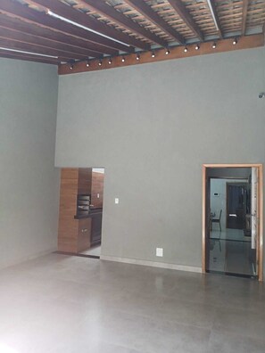 A spacious room with a high ceiling, exposed wooden beams, and a built-in wooden cabinet. - Charming house near the state hospital, bakery, supermarket, and pharmacy. (franca)