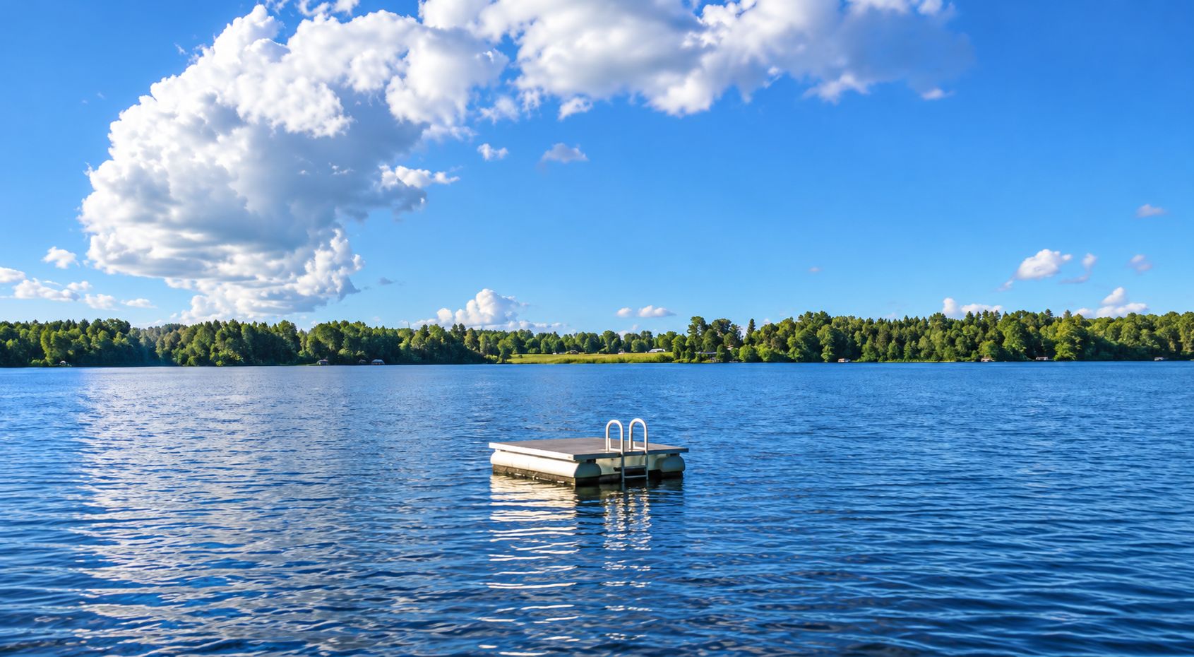 A calm lake with a dock and a forested island in the background.