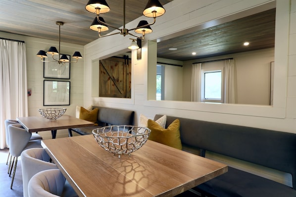 A modern dining area with a wooden table, a wire basket, and a bench. - "The Harrisburg" by OVR (Oxford)