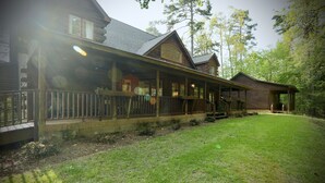 A log cabin with a covered porch, a front deck, and a well-maintained lawn. - "The Laurel" by OVR (Oxford)