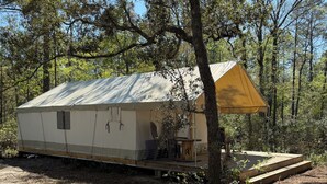 Ein Wohnmobil mit einer großen Veranda, einer kleinen Terrasse und einem überdachten Außenbereich.