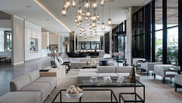 Uma sala de estar moderna com sofá, mesa de centro e iluminação pendente.