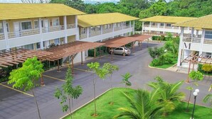 Ein Hotel mit mehreren Gebäuden, überdachtem Parkplatz und Grünflächen.