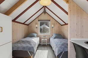 A room with two beds, a small table, a window, and a ceiling fan. - Spacious holiday home 150 m from the beach (Ålbæk)