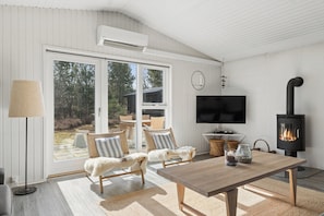 A modern living room with a fireplace, comfortable seating, and a large TV. - Spacious holiday home 150 m from the beach (Ålbæk)