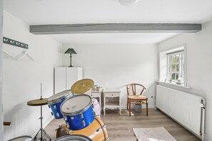 A room with a drum set, a desk, a chair, and a radiator. - Spacious holiday home near Ribe for 11 (Ribe)