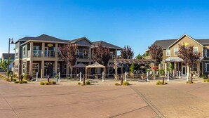 A hotel with multiple buildings, outdoor seating areas, and a paved courtyard. - 2BR Oyhut Bay Condo | Fireplace | Private Deck (Ocean Shores)