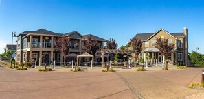 A hotel with multiple buildings, outdoor seating areas, and a paved courtyard. - 2BR Oyhut Bay Condo | Fireplace | Private Deck (Ocean Shores)