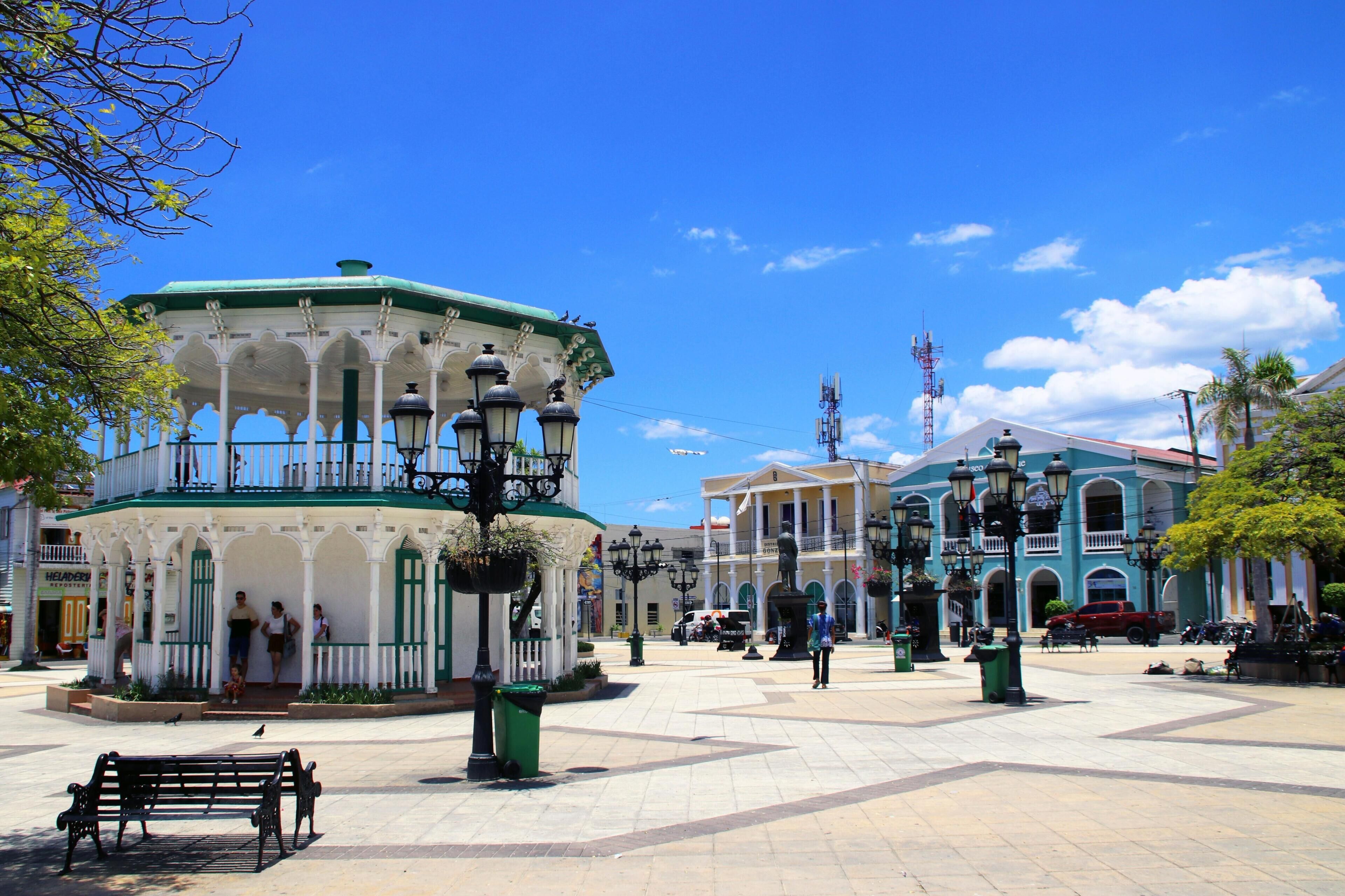 A plaza with a gazebo, benches, and a statue.