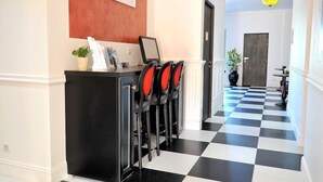 A hotel reception area with a checkered floor, a reception desk, and a door in the background. - Boutique Hotel Liberata (L'Île-Rousse)