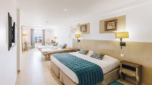 A hotel room with two beds, a desk, a chair, a TV, and a view of the sea. - Boutique Hotel Liberata (L'Île-Rousse)