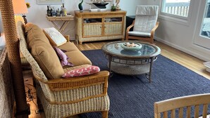Ein Wohnzimmer mit Sofa, Sessel, Couchtisch und Esstisch.